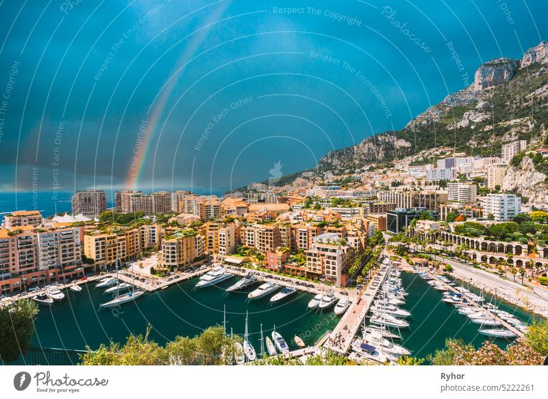 Yachten vertäut in der Nähe von Stadt Pier, Jetty In Sunny Summer Day. Monaco, Monte Carlo Architektur. Geänderter Himmel mit Regenbogen schön Liegeplatz blau