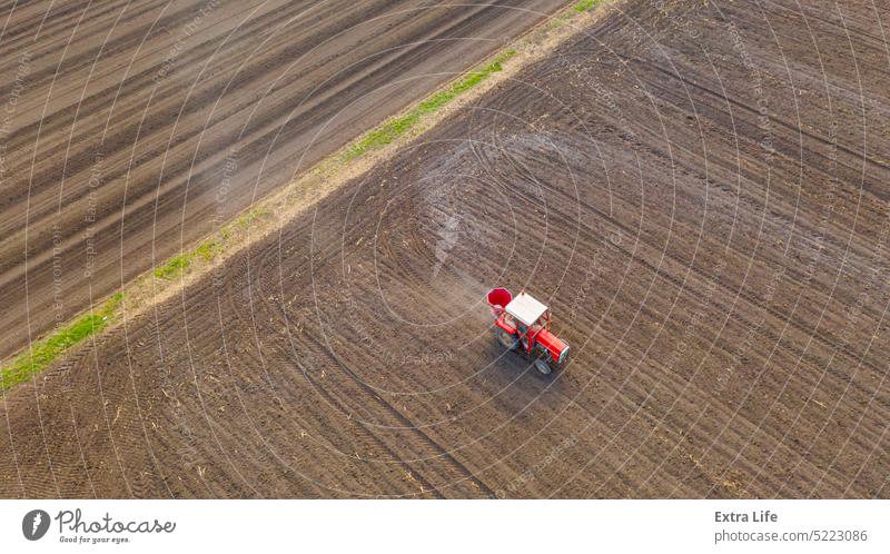 Luftaufnahme eines Traktors beim Ausbringen von Dünger auf einem landwirtschaftlichen Feld oben Ackerbau Agronomie anbaufähig künstlich Gerste Pflege Müsli