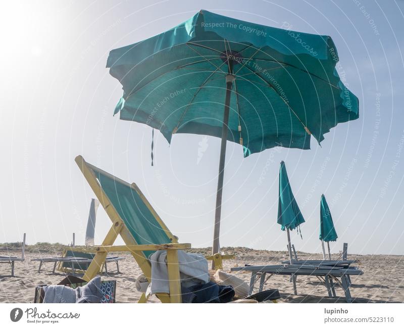 Liegestühle mit Sonnenschirmen an einsamen Strand Liegstuhl aufgeklappt offen geschlossen Sand vormittags Europa Italien Urlaub Aussenaufnahme Reisen Himmel