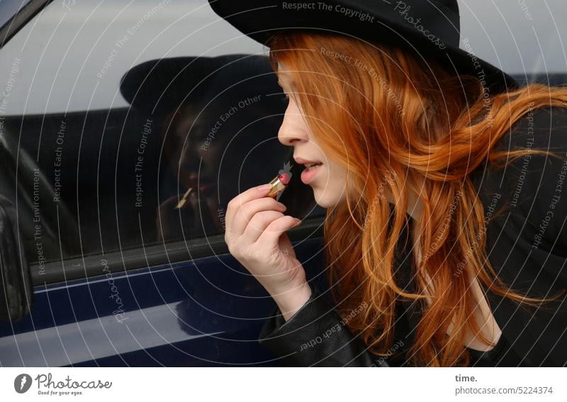 rothaarige Frau mit Hut, sich in einem Autoseitenspiegel schminkend Porträt Konzentration Leben ruhig geduldig Gelassenheit gewissenhaft Wachsamkeit schön