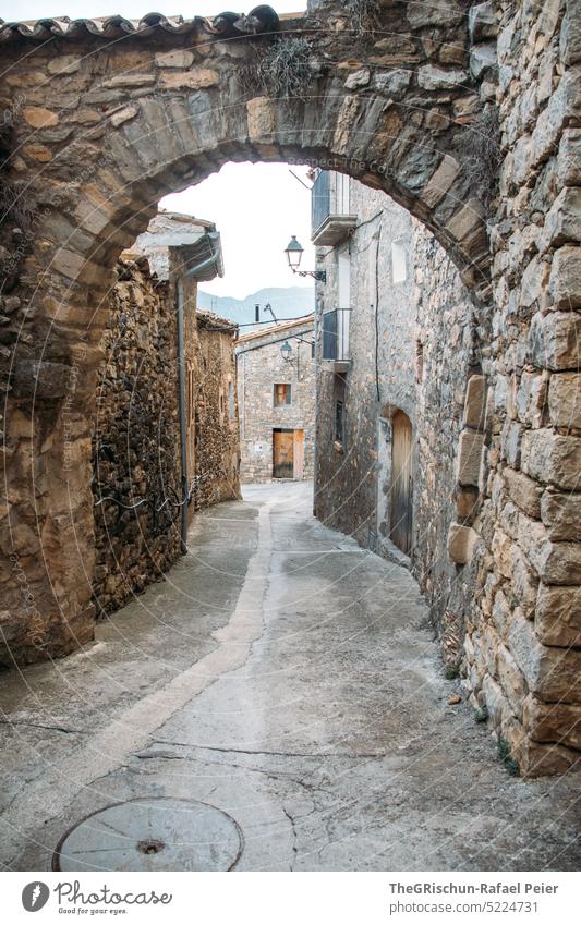 Gasse mit Torbogen und Häuser im HIntergrund Mauer Spanien Dorf alt Außenaufnahme Haus Altstadt Wand Menschenleer Fassade