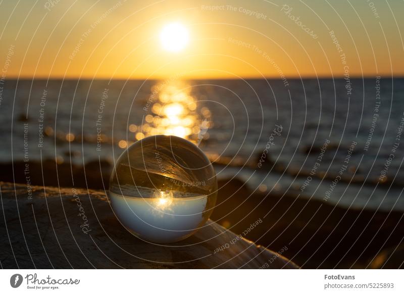 Kugel aus Glas liegt auf einem Stein, in dem sich der Strand und das Meer spiegeln Ansicht Klima Natur Wasser Ball Land Objektivkugel ruhig Wetter MEER
