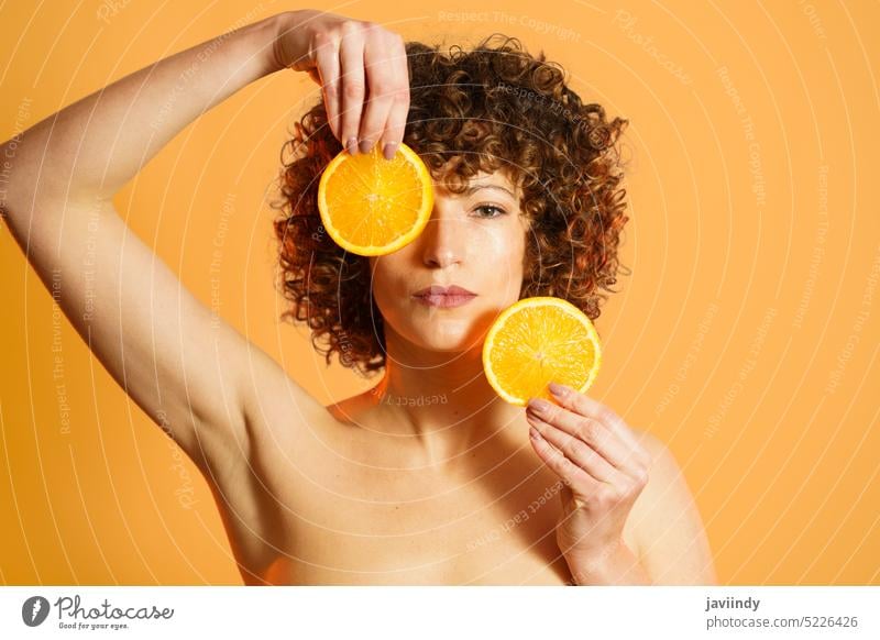 Erwachsene Frau mit Stücken einer frischen Orange Deckblatt orange Schönheitsprogramm Scheibe Zitrusfrüchte ernst natürlich Farbe hell Erwachsener reif Wellness
