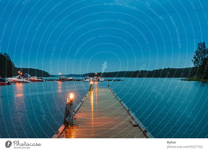 Schweden. Schöne hölzerne Pier in der Nähe von See im Sommer Abend Nacht. See oder Fluss Landschaft Szene Boot Windstille Licht Park Schwedisch Wasser Natur