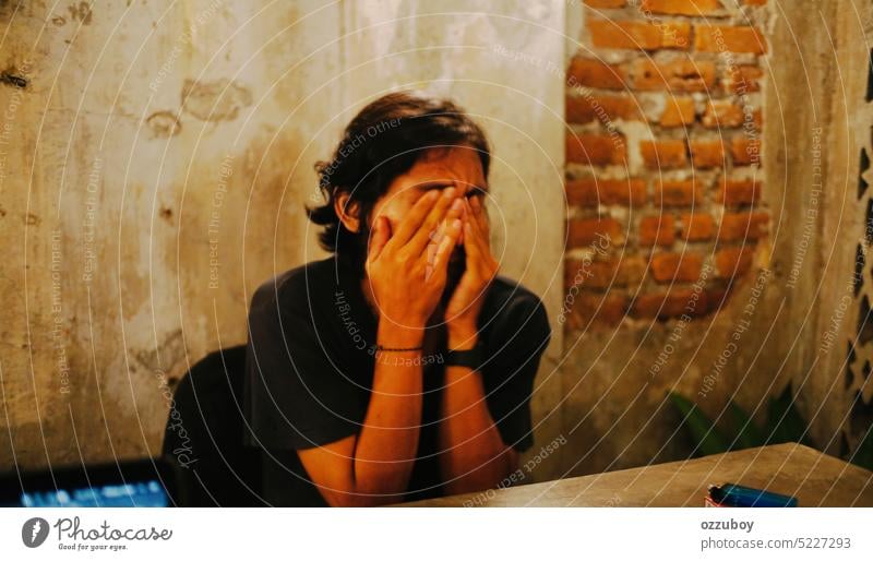 Porträt eines gestressten asiatischen jungen Mannes, der sein Gesicht mit zwei Händen verdeckt Person Hand Emotion Ausdruck Deckung Angst traurig Stress