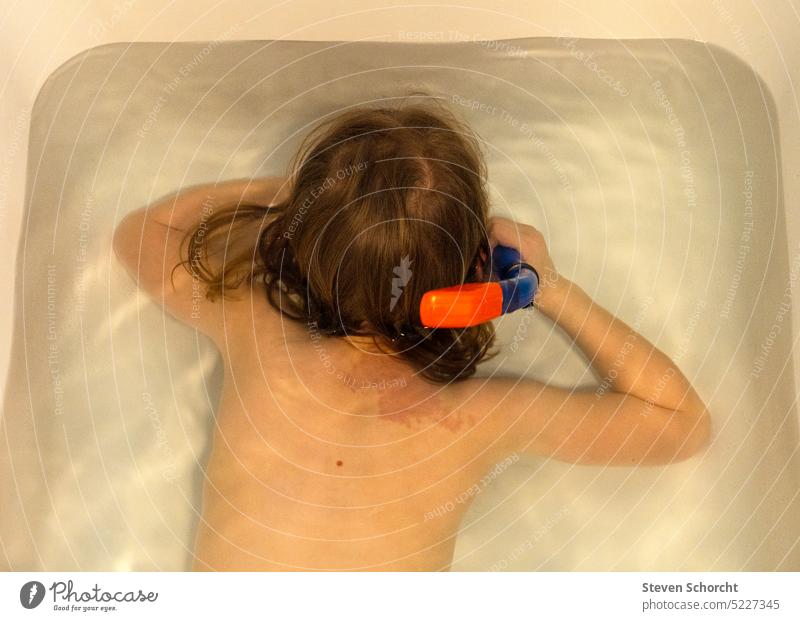 Kind badet in einer weißen Badewanne und übt tauchen mit einem Schnorchel und Taucherbrille baden Wasser Schwimmen & Baden Waschen Sauberkeit nass Haut Mensch