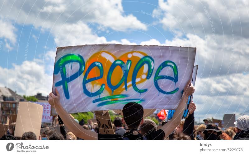 Mensch hält ein Transparent mit der Aufschrift " Peace " in die Höhe frieden Wort Friedenswunsch Antikriegsdemonstration Ukraine Ukrainekrieg Friedensdemo