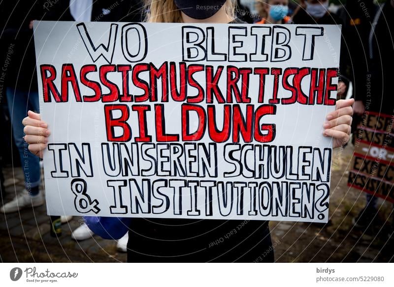Eine Demonstrantin prangert an das in deutschen Bildungseinrichtungen Rassismus zu wenig thematisiert wird. thematisieren Schulen rassismuskritische Bildung