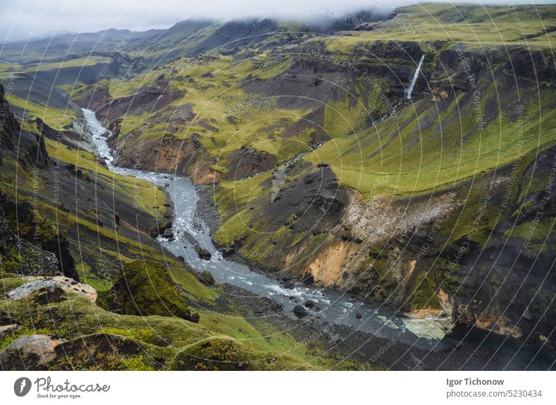 Isländische Landschaft mit Hochlandtal und Fluss Fossa mit blauem Wasserlauf, grünen Hügeln und moosbewachsenen Klippen. Süd-Island haifoss Tal strömen Sommer