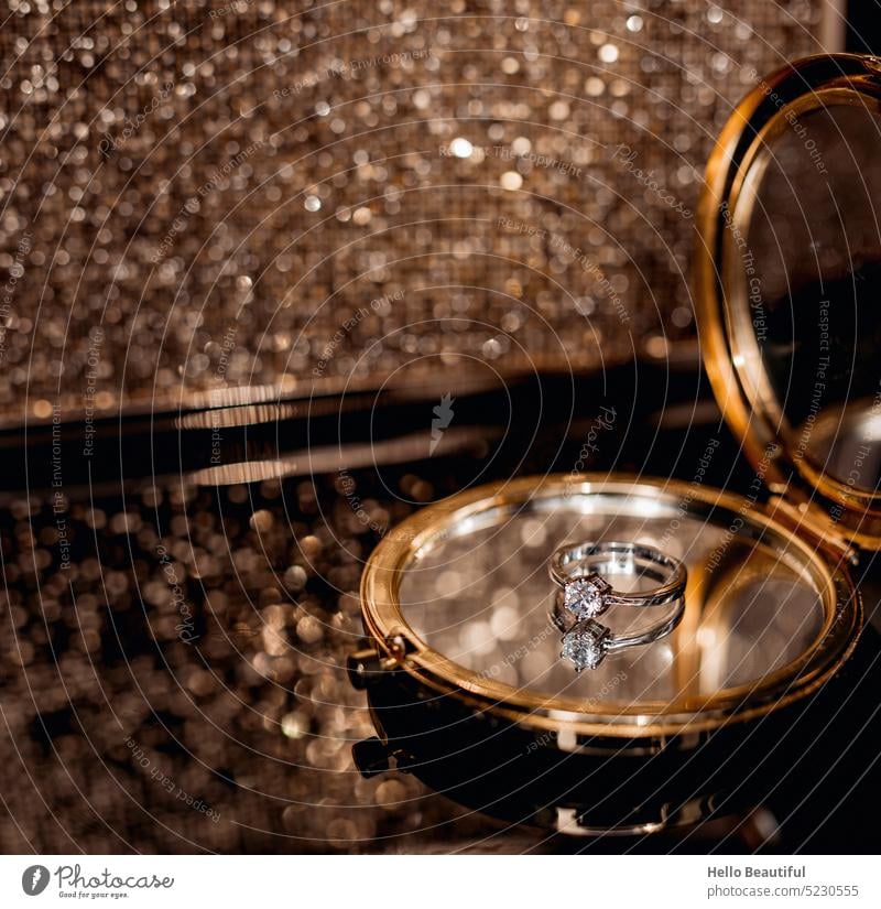Ring auf einem Spiegel vor einer goldenen Handtasche Verlobung Verlobungsring Hochzeit glitzern glitzernd glamourös Glamour glamour-girl Geld Reichtum Wohlstand
