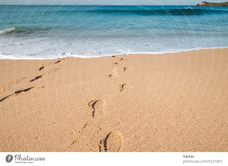 Fußabdrücke im Sand von einem Mann, der am Sandstrand von Praia da Ilha do Pessegueiro in der Nähe von Porto Covo, Westportugal, in den Tiefen des Atlantiks versinkt