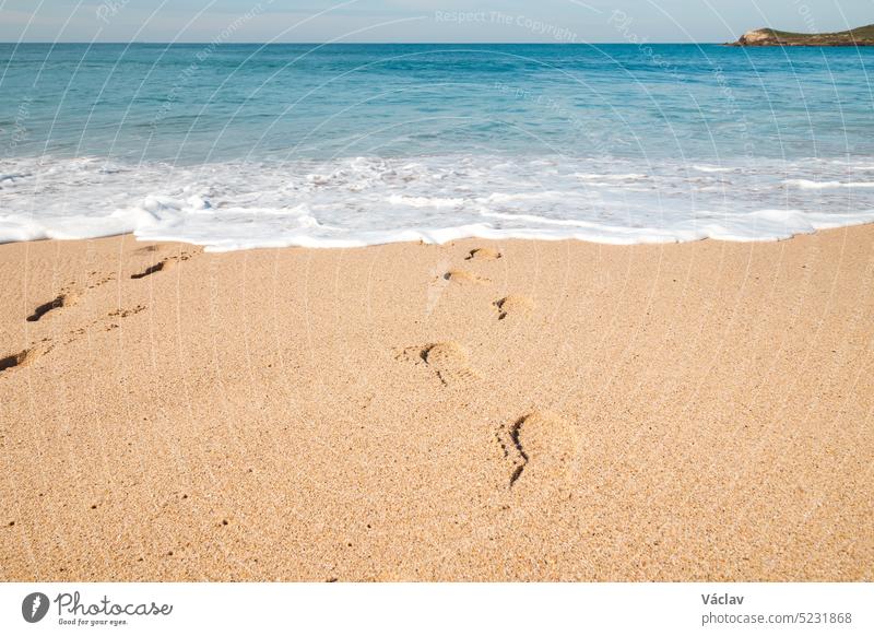 Fußabdrücke im Sand von einem Mann, der am Sandstrand von Praia da Ilha do Pessegueiro in der Nähe von Porto Covo, Westportugal, in den Tiefen des Atlantiks versinkt
