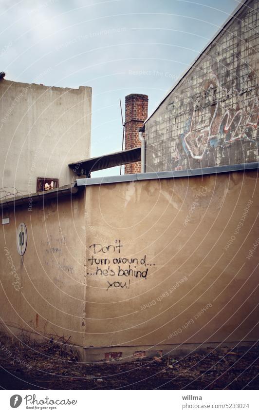 Don't turn around, he's behind you.  Wirf den Teufel nicht an die Wand! Altbau Graffiti Gebäude Spruch Text dreh dich nicht um Schmiererei Abrissgebäude