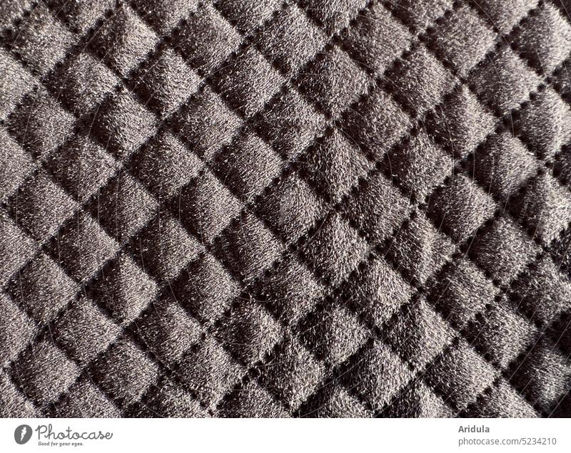Gestepptes Polster gesteppt Bezug Stoff Detailaufnahme Sofa Schatten Material grau Rautenmuster Quadrat Karo Naht nähen Hintergrund