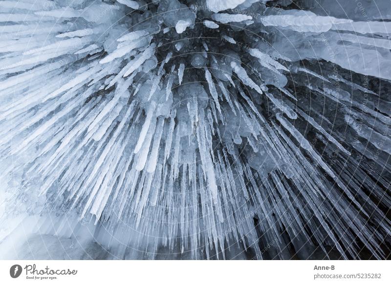 spitze Eiszapfen in einer vereisten Felshöhle von unten fotografiert lang über mir Wasser gefroren eisig frostig bitterkalt Kälte Höhle frieren Frost Winter