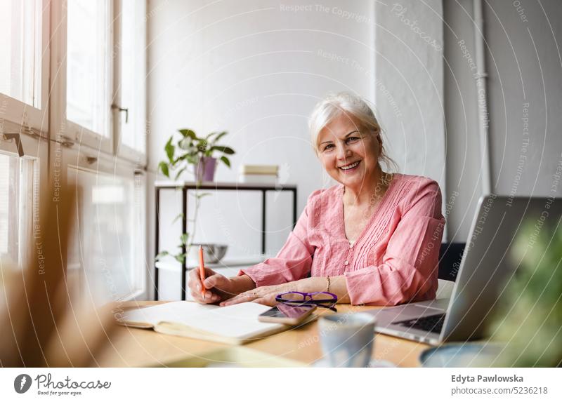 Porträt einer lächelnden reifen Geschäftsfrau, die in einem Büro arbeitet echte Menschen Senior im Innenbereich Loft Fenster heimwärts reifer Erwachsener