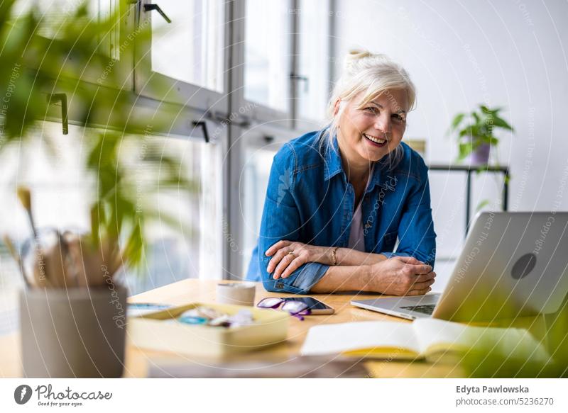Porträt einer lächelnden reifen Geschäftsfrau, die in einem Büro arbeitet echte Menschen Senior im Innenbereich Loft Fenster heimwärts reifer Erwachsener