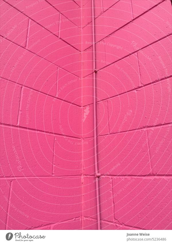 Rosa Wände mit Metallrohr rosa Wand rosa Wände Hellrosa Mauern gehen hoch Eckstoß Farbe Monochrom Muster leuchtende Farben farbenfroh Hintergrund Ziegel