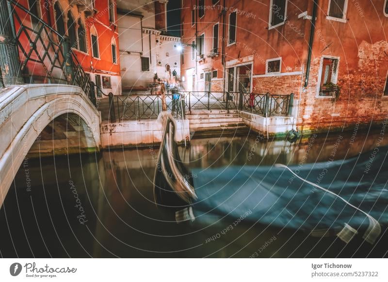 Venedig Gondel Boot in kleinen Kanal mit Bogenbrücke in Lagunenstadt Venedig in der Nacht. lange Belichtung Venezia Italien Ansicht Großstadt Straße Italienisch