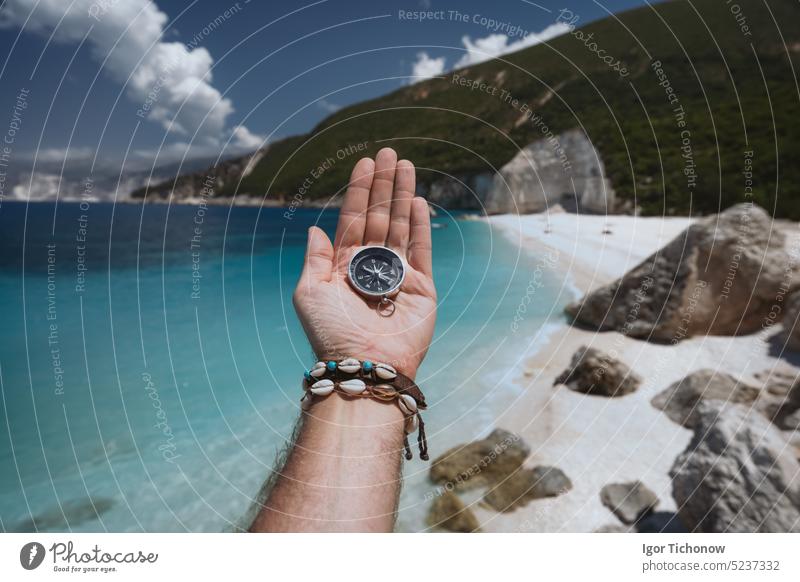 Hand hält einen Kompass am Strand im Hintergrund Beteiligung MEER Urlaub reisen Gerät verirrt Reise Sommer Osten wandern Erkundung Regie Anleitung Meer