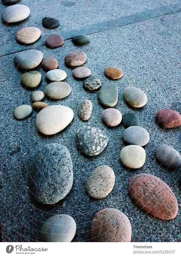 Am Strand gesammelte Kieselsteine ruhen auf dem Gartentisch Steine Natur Sammlung Tischplatte Formen Licht Schatten Dänemark