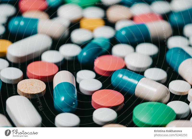 Thema Apotheke. Multicolored isoliert Pillen und Kapseln auf schwarzer Oberfläche. Vitamine, Medikamente Konzept. COVID-19, Coronavirus, Epidemie Tablette