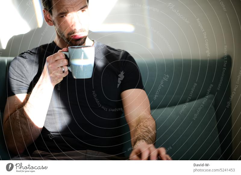 Mann trinkt einen frischen Kaffee am Morgen Pause Kaffeepause Sonnenstrahlen Kaffeetrinken Stress Ruhe Auszeit nachdenklich Gedanken Zweifel Sonnenlicht Licht
