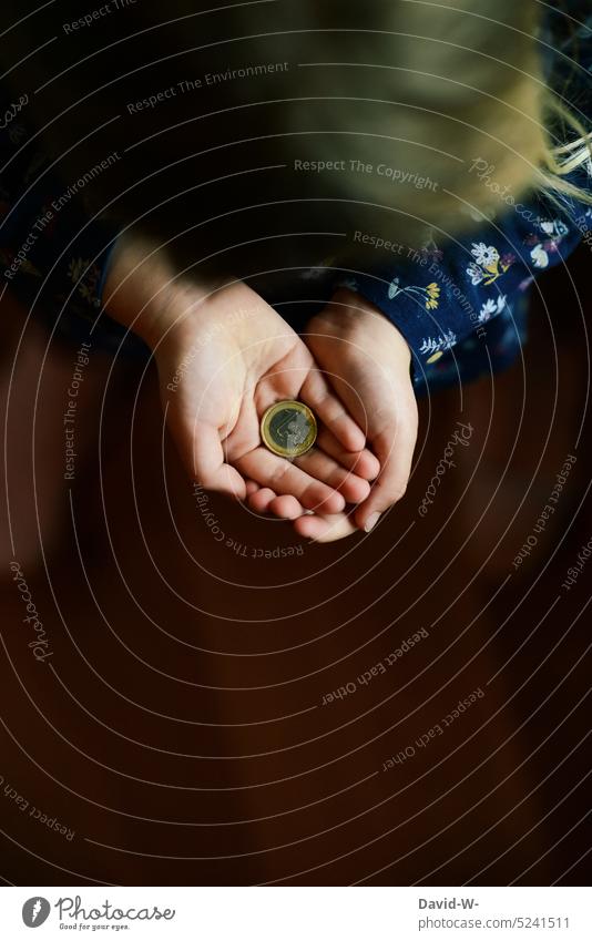 sparen für die Zukunft - Kind hält einen Euro in der Hand Geld Zukunftsangst Euromünzen Geldmünze nachdenklich ungewiss Kindheit Mädchen Investition Erfolg