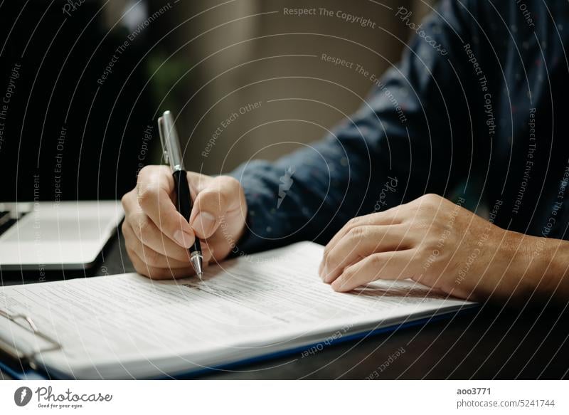 Geschäftsmann unterzeichnet Dokumente mit einem Stift, der die Unterschrift Vertrag und Partnerschaft auf dem Schreibtisch. Unterzeichnung Auftrag Schriftstück