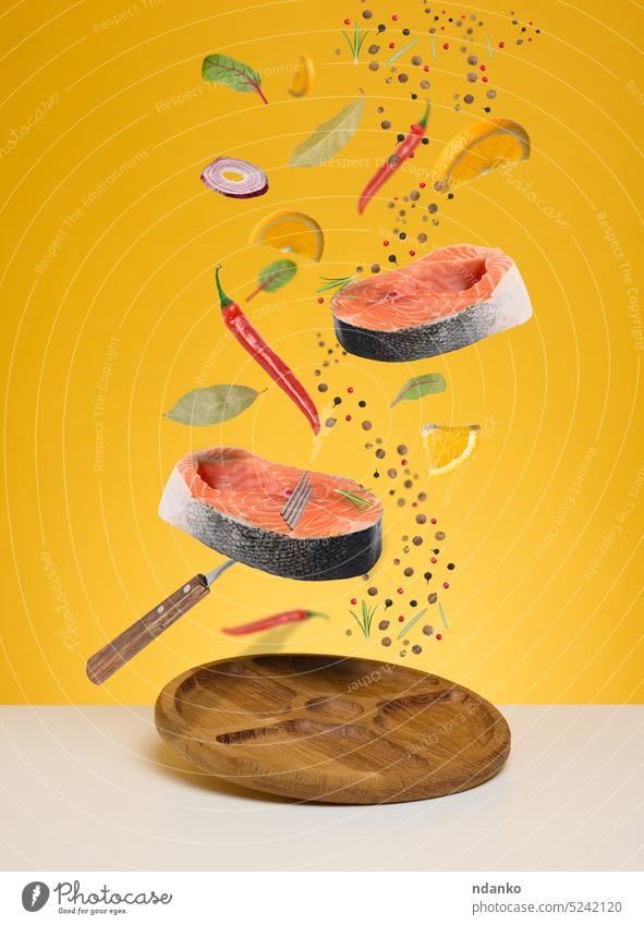 Frische Lachsstücke, Zitrone, Gewürze schweben über einem weißen Tisch. Zutaten für das Abendessen Rosmarin Gabel Blatt Holzplatte Levitation Bestandteil