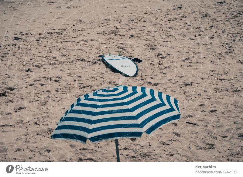 Der Sommer kann kommen. Sonnenschirm und Surfbrett sind schon da. Sonnenschirm-Strand Schönes Wetter Außenaufnahme Tag Farbfoto Sommerurlaub Sonnenbad Küste