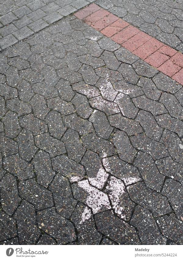 Weiße verblasste aufgemalte Sterne auf dem grauen Verbundpflaster eines Schulhof nach einer Abiturfeier am Niklas Luhmann Gymnasium in Oerlinghausen bei Bielefeld im Teutoburger Wald in Ostwestfalen-Lippe