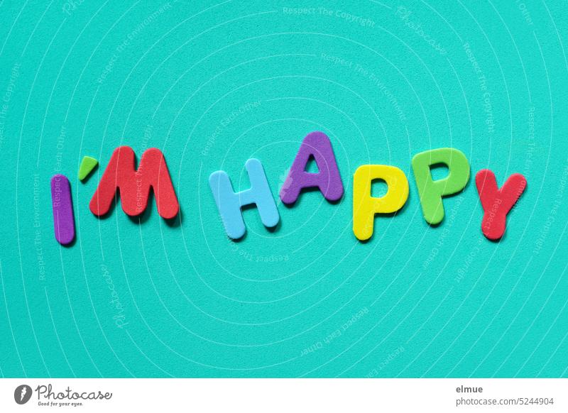 I'M HAPPY  steht in verschieden farbigen Buchstaben auf türkisem Untergrund I'm happy fröhlich zufrieden englisch bunt Farbe ich freue mich ich bin froh