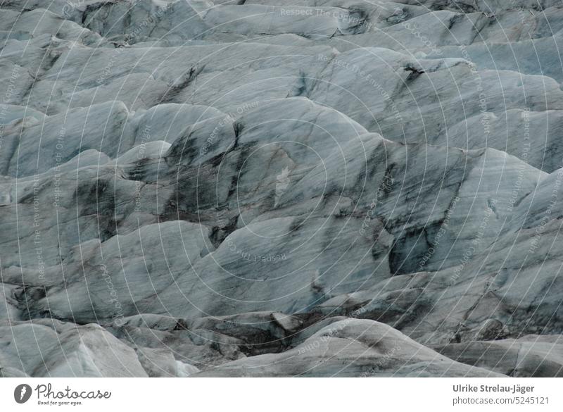 Gletschereis mit Vulkanasche Eis Eisformationen Asche kalt Klimawandel Landschaft Natur Wasser Urelemente Frost Gletscherschmelze hellblau weiss grau schmelzen