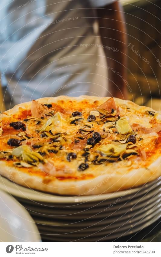 Hausgemachte Pizza nach italienischer Art. Frisch gekneteter Teig, von Hand zerdrückte Tomaten und eine perfekte Mischung aus Mozzarella und Parmesan machen diese Pizza zu einem wahren Kunstwerk