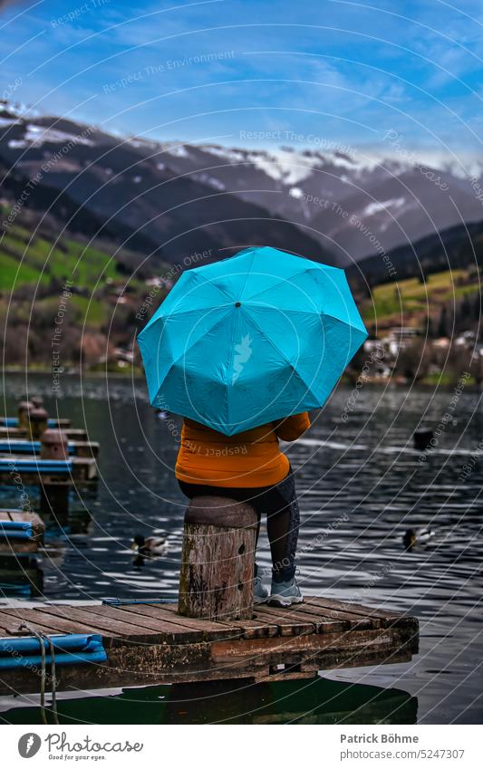 Frau mit Blauem REgenschirm vor einem See Regenschirm blau Berge u. Gebirge Steg Wasser Landschaft Canon Fotografie Fotoserie
