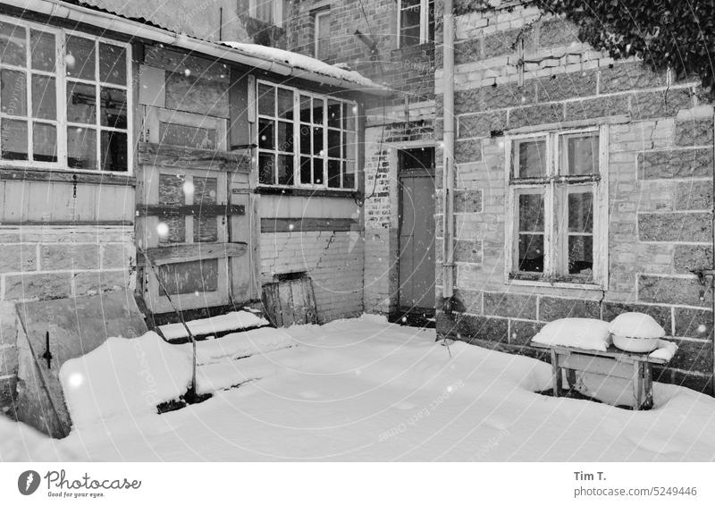 ein verlassener Bauernhof an der Oder Winter s/w Schnee Hof Innenhof Polen Schwarzweißfoto Menschenleer Tag Außenaufnahme Hinterhof Altbau Architektur Haus