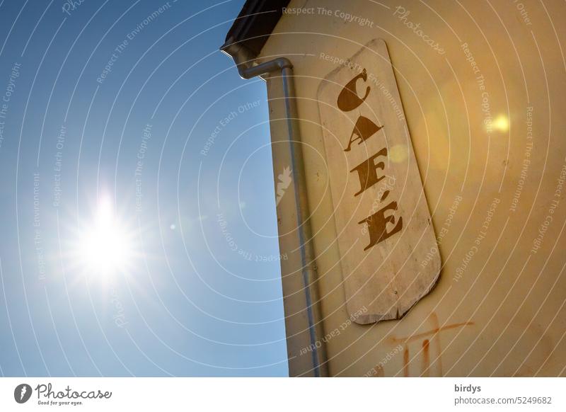 Sonnenbeschienenes Cafe mit blauen Himmel Café Schild geniesen Gegenlicht Wärme Gastronomie Haus Auszeit Sommer Sonnenschein location blauer Himmel