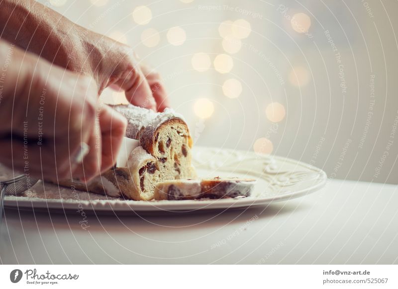 Stollen Lebensmittel Teigwaren Backwaren Kuchen Dessert Christstollen gold Weihnachten & Advent Messer schneiden Rosinen Hand festhalten Farbfoto Innenaufnahme