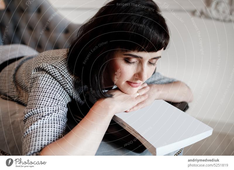 Müde junge Frau oder Unternehmer schlafen auf dem Sofa nach langen Stunden Arbeit am Laptop, Overworked erschöpft. Geschäftsfrau ruht ihren Kopf auf einem leeren Papiere und Computer, Gefühl gestresst. mock up