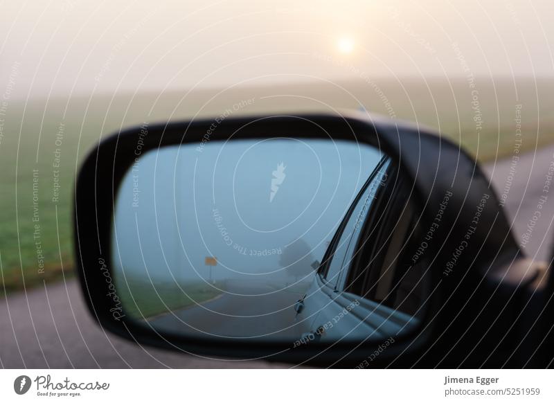 Ein Auto fährt eine Straße entlang, im Seitenspiegel spiegelt sich der Himmel und die Straße. fahren Spiegel Transport Nebel Verkehr Fahrzeug Verkehrswege