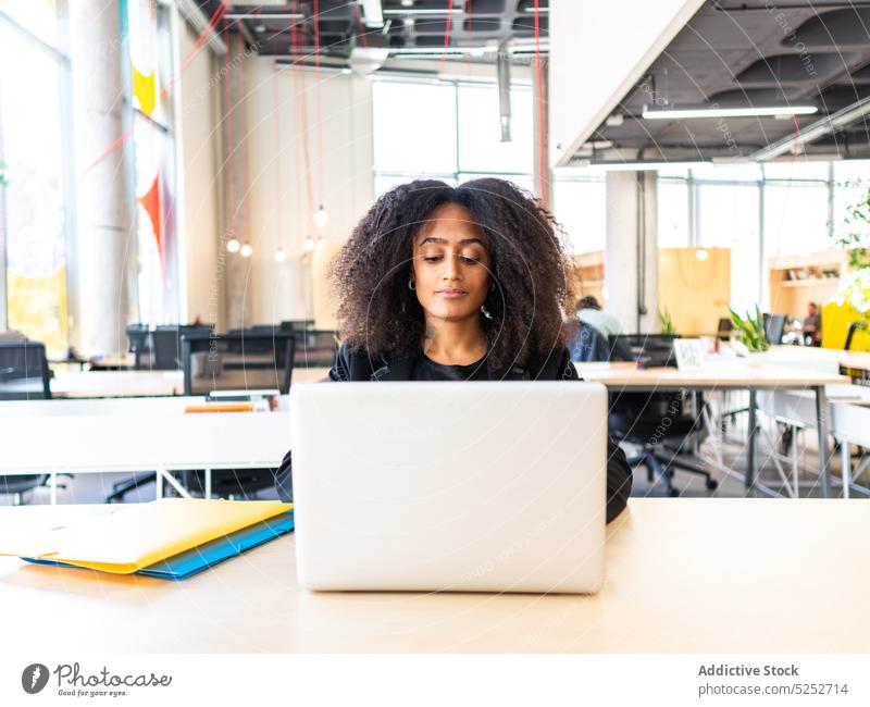 Konzentrierte schwarze Mitarbeiterin arbeitet am Laptop im Büro Frau benutzend Anschluss Arbeit Projekt Gerät Job Konzentration jung Afroamerikaner ethnisch