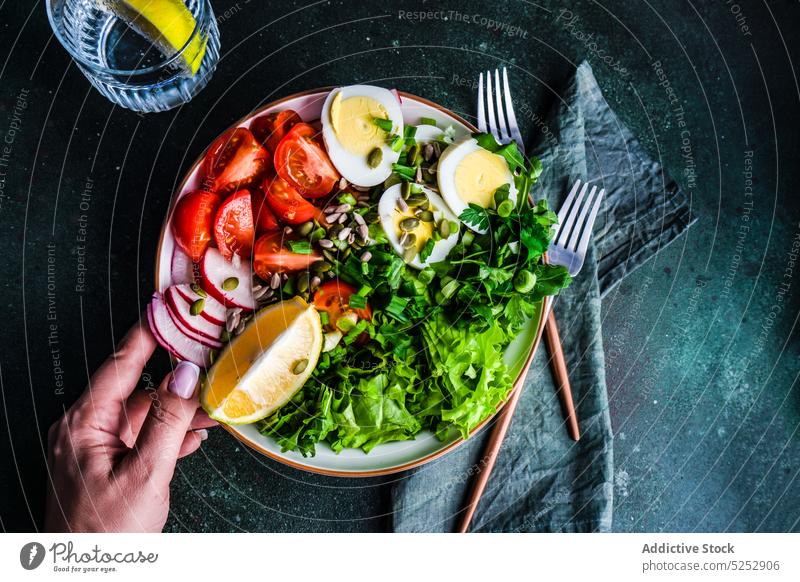 Anonyme Person isst gesunden Rohkostsalat gekocht Besteck Abendessen Ei Lebensmittel frisch Glas Hand Gesundheit Kraut Halt Zitrone Salat Mahlzeit Serviette