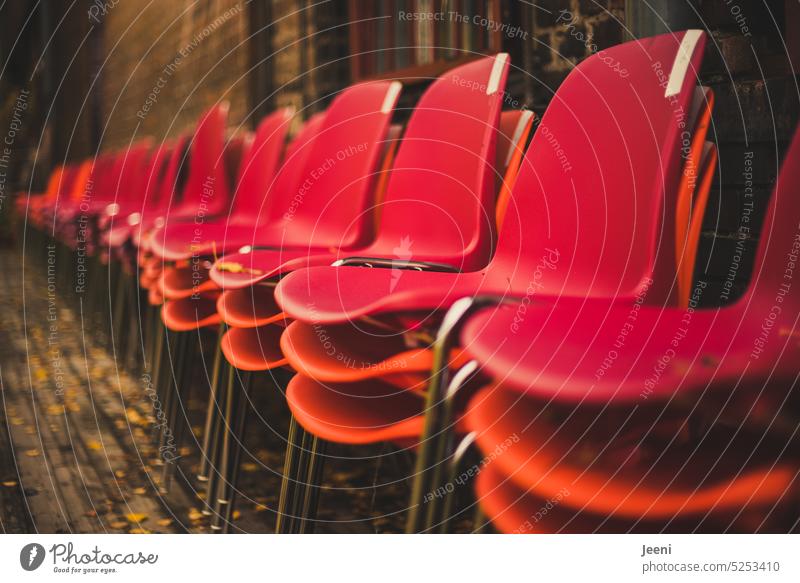 Viele rote und orangerote Stühle nebeneinander aufgestapelt Sitz Stuhlreihe Platz Strukturen & Formen Veranstaltung Publikum Möbel Theater Tribüne Muster Stapel