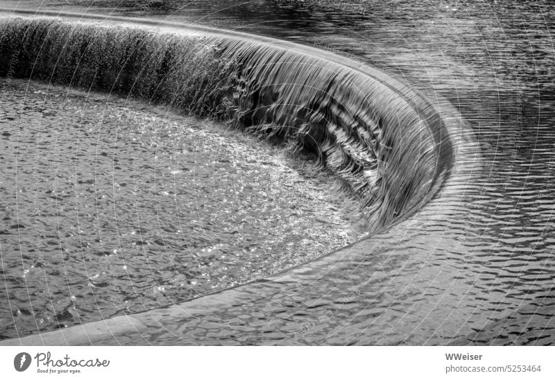 Wasser fließt in ein rundes Becken, Sonnenlicht glitzert darauf strömen fließen Springbrunnen harmonisch groß klassisch Wind Gischt Tropfen Wellen nass Bewegung