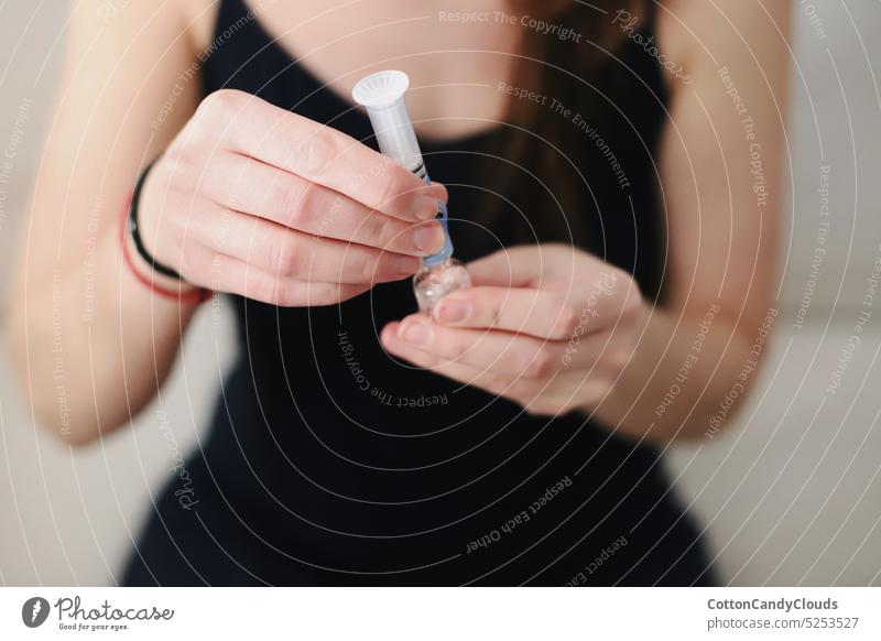 Frau füllt das Reservoir ihrer Insulinpumpe mit Insulin auf Auffüllen Stausee Typ-1-Diabetes Diabetes-Pflege medizinische Ausrüstung Diabetesbedarf