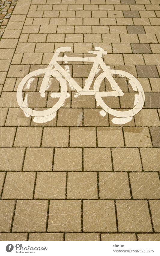 Reste eines alten und ein darüber liegendes Piktogramm eines Fahrrades auf Steinplatten Radweg Fahrradweg Fahr Rad! Radfahren alt und neu überstreichen Blog