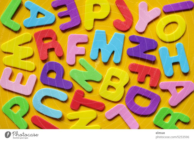 verschieden farbige Buchstaben auf gelbem Untergrund / Buchstabensalat schreiben bunt Farbe Moosgummi Blog Schrift Alphabet Schriftzeichen Alphabetschrift