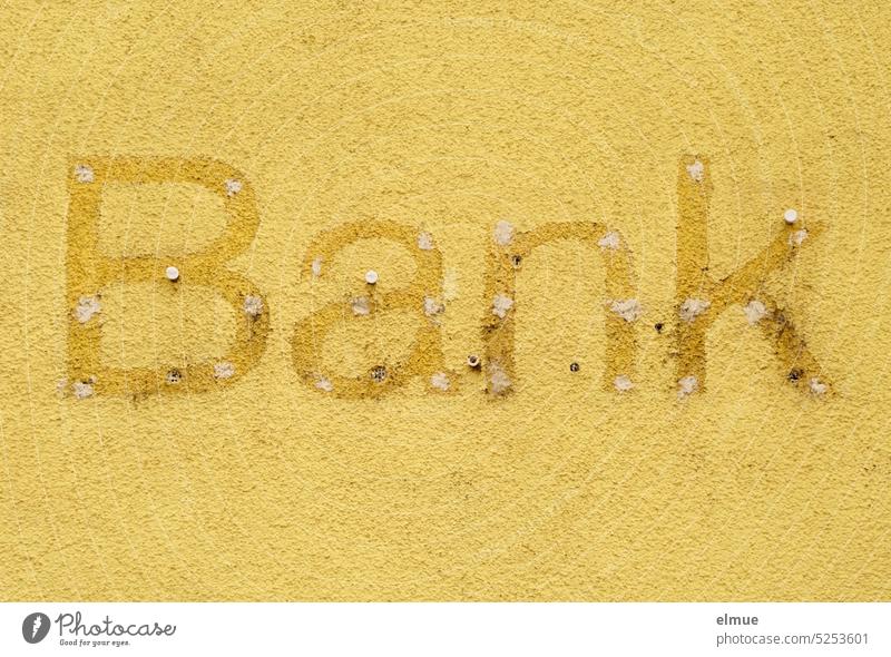 Reste eines Reklameschildes  - Bank - an einer gelben Wand Geldinstitut kaputt Bankgeschäft marode Pleite Bankenkrise Gelddepot geschlossen Vergangenheit