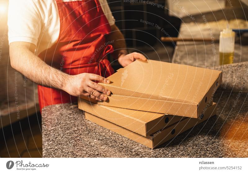 Pizzabäcker verpackt Pizzen in einem Karton für die Auslieferung in einer italienischen Pizzeria Rudel Pferch geschmackvoll kitschig Kasten Mann Salami